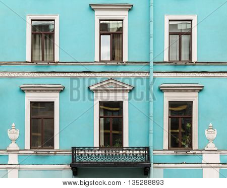 Several windows in a row and balcony on facade of urban office building front view St. Petersburg Russia