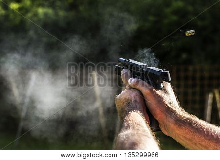 Person is holding a gun and it's aiming at something.