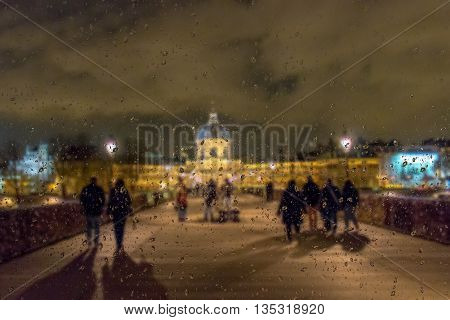 Abstract blurry background with water drops: view through the window Paris by night France