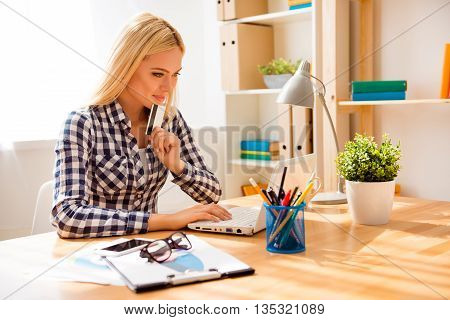 Portrait Of Minded Woman Holding Bank Card And Doing Shopping