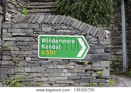 A UK road sign, showing direction to Windermere and Kendal