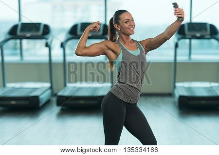 Pretty Girl Taking Selfie And Posing Biceps Pose