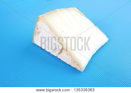 light swiss gauda cheese on blue board