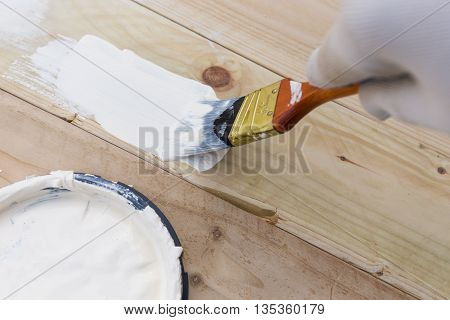 Painting timber boards outside with the white paint or white coloured emulsion using 2 inches painting brush.