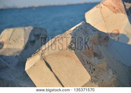 Close Up Of Breakwater Made Of Concrete Tetrapods In The Sunset, With The Calm Sea In Background. Se