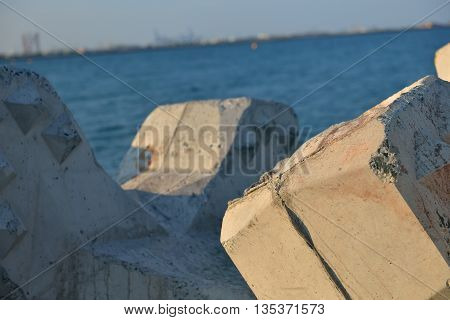 Close Up Of Breakwater Made Of Concrete Tetrapods In The Sunset, With The Calm Sea In Background. Se