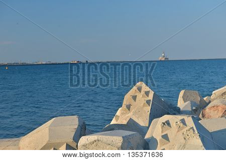 Close Up Of Breakwater Made Of Concrete Tetrapods In The Sunset, With The Calm Sea In Background. Se