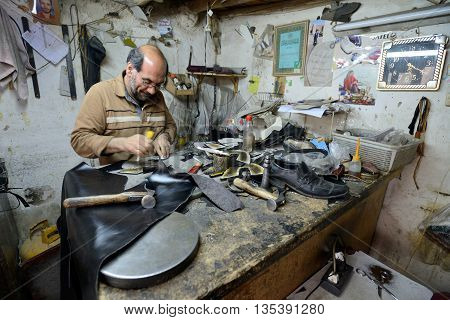 ISFAHAN - APRIL 18: Unknown man making shoes in a market (Isfahan Bazaar) in Isfahan Iran on April 18 2015. Bazaar is the most important tourist attraction in Isfahan Iran.
