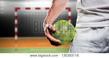 Sportsman holding a ball against digital image of handball goal