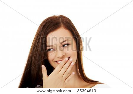 Young woman giggles covering her mouth with hand