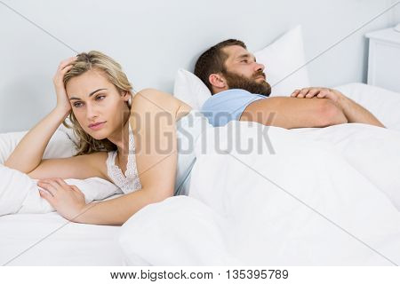 Couple upset after having a fight on bed in bedroom