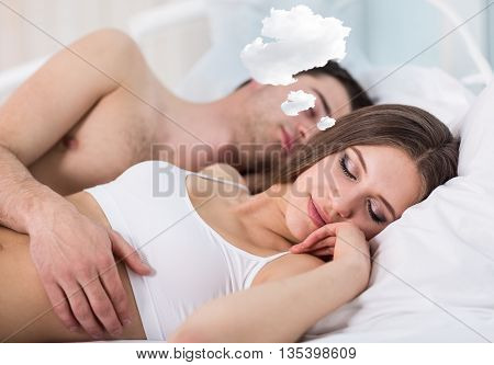 Woman with thoughts cloud sleeping in bed with her boyfriend