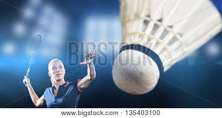 Badminton player playing badminton against composite image of spotlight