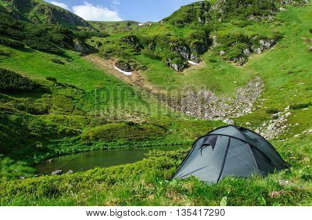 Grey big tent by the lake in the Carpathians