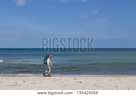 Tisvilde, Denmark - June 20, 2016: An elderly lady hiking on Tisvilde beach.