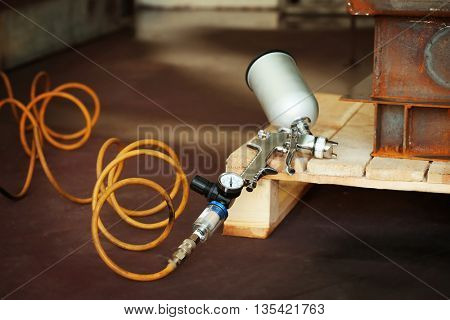 Spray gun on wooden stand, closeup
