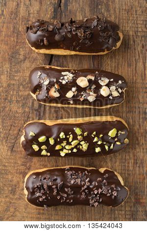 Eclairs with chocolate ganache with different toppings
