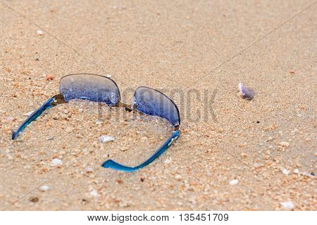 Sunglasse blue on sand. in a holiday