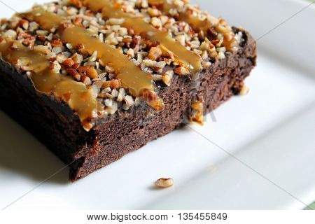 Chocolate brownie with caramel and pecan nuts.