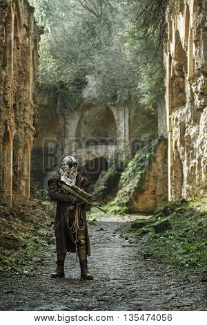Nuclear post-apocalypse. Sole survivor in tatters and gas mask on the ruins of the destroyed city