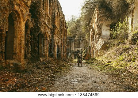 Nuclear post-apocalypse. Sole survivor in tatters and gas mask on the ruins of the destroyed city