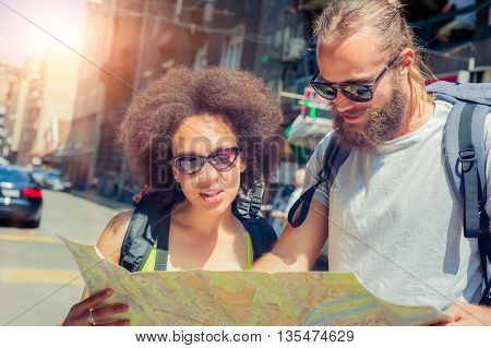 Young beautiful happy couple looking on touristic map in Belgrade