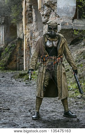 Nuclear post-apocalypse. Sole survivor in tatters and gas mask on the ruins of the destroyed city