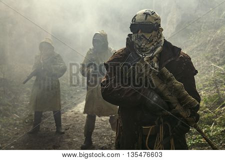 Nuclear post-apocalypse. Survivors in tatters and gas mask on the ruins of the destroyed city