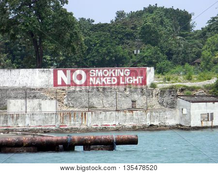 CEBU CITY, CEBU / PHILIPPINES - JULY 30, 2011: A sign indicates that smoking and naked lights are prohibited near the shore of Cebu City.