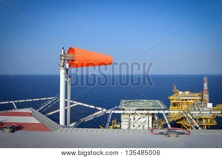 The wind sock is set on the oil rig to showing wind direction for helicopter landing .