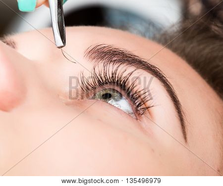 Beautiful young woman eyelash extension. Woman eye with long eyelashes. Beauty salon concept.
