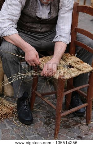 Man Mender Of Chairs While Repairing Old Wooden Chair