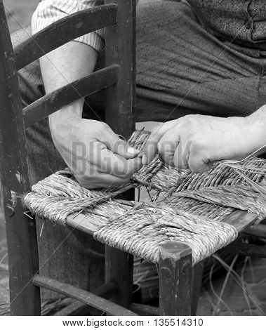Mender Of Chairs While Repairing An Old Chair With Straw
