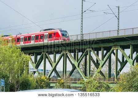 ESSEN KETTWIG NRW GERMANY - APRIL 28 2016: Express train crossing the railway bridge in Essen Kettwig an der Ruhr in Germany. By powered express train toward Duesseldorf.