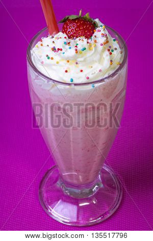 strawberry smoothie with candy sprinkles in a glass
