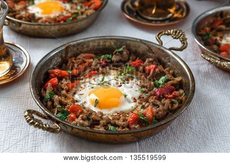 Fried egg with mince meat in traditional turkish pan close view