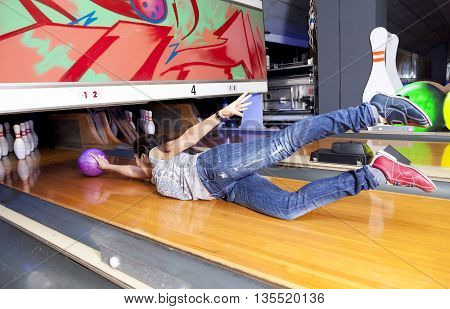 Young Woman Sliding Down A Bowling Alley