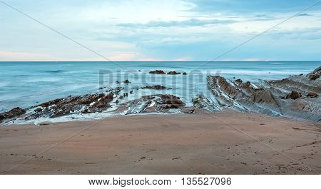 Twilight Ocean Coast With Ribbed Stratiform Rock.