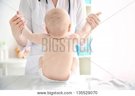 Doctor doing exercises with baby