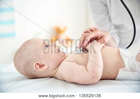 Professional pediatrician examining infant