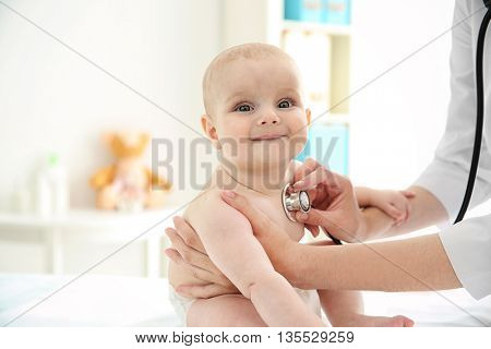 Professional pediatrician examining infant