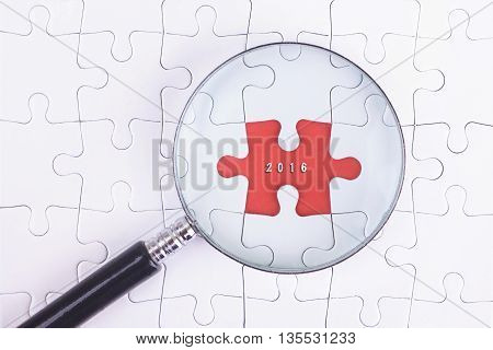 Business Concept - Magnifier Glass on white puzze with 2016 Word