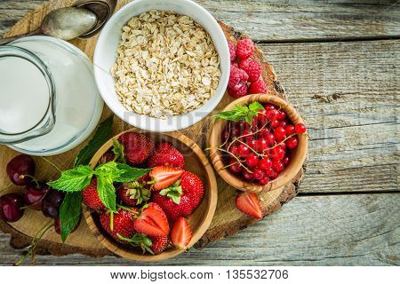 Oatmeal with berries on rustic wood background, copy spce
