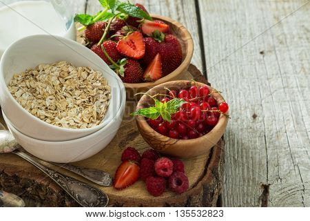 Oatmeal with berries on rustic wood background, copy spce