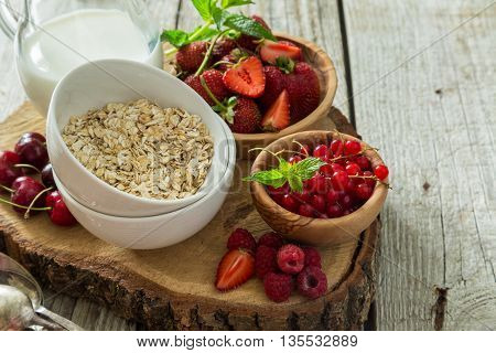Oatmeal with berries on rustic wood background, copy spce