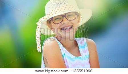 Girl.Happy girl teen pre teen. Girl with glasses. Girl with teeth braces. Young cute caucasian blond girl in summer outfit.