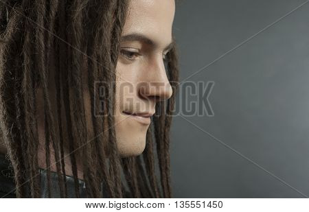 Young man's portrait. Stylish handsome sexy Guy with Dreadlocks in black leather fashionable jacket Close-up face. Tribal Style. Trendy youthful man's look