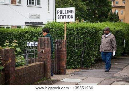 LONDON, UNITED KINGDOM - JUNE 23: A man holding an umbrella passes by a polling station during the British EU Referendum in London, United Kingdom on June 23, 2016.
