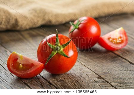 Red tomatoes on wooden surface. Selective focus