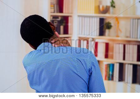 Man in office touching his neck with his hand, pain is common in offices.